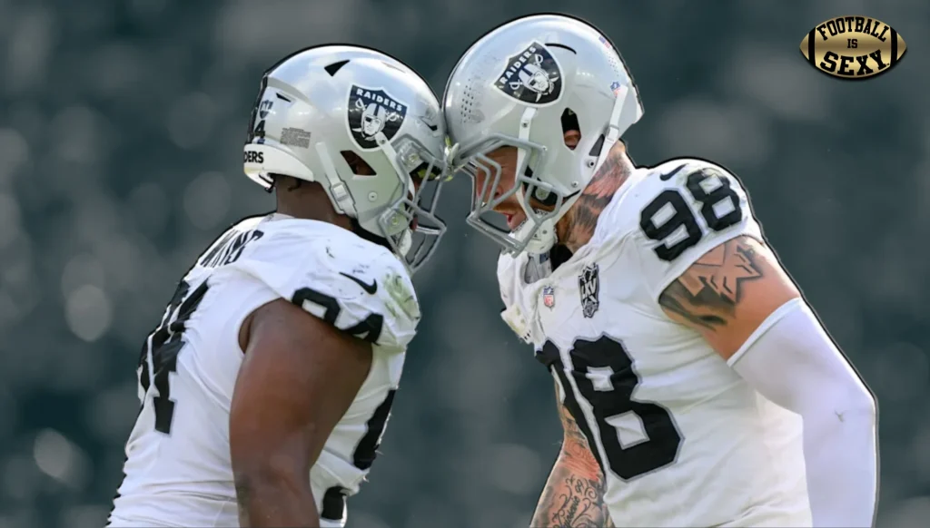 Two football players bumping helmets on field