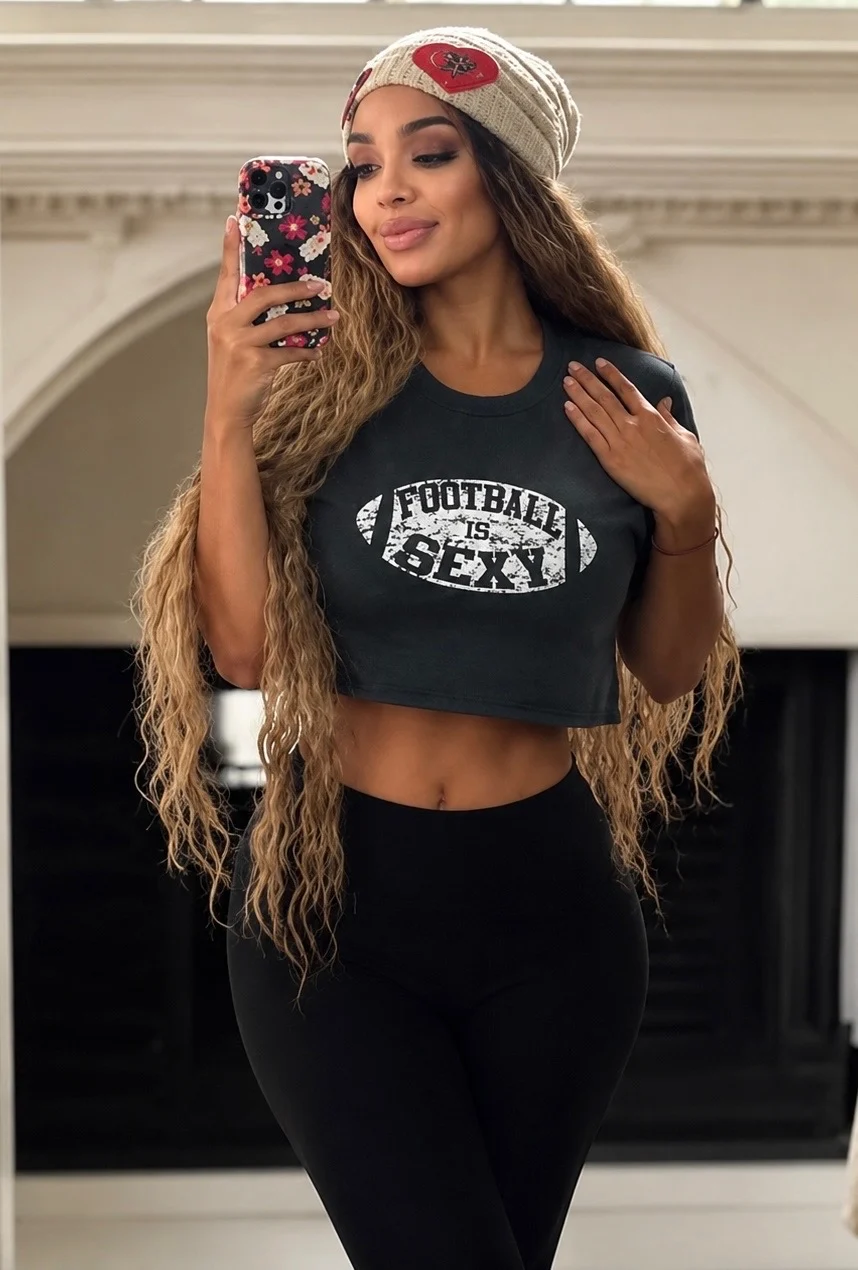 Woman mirror selfie wearing football crop top